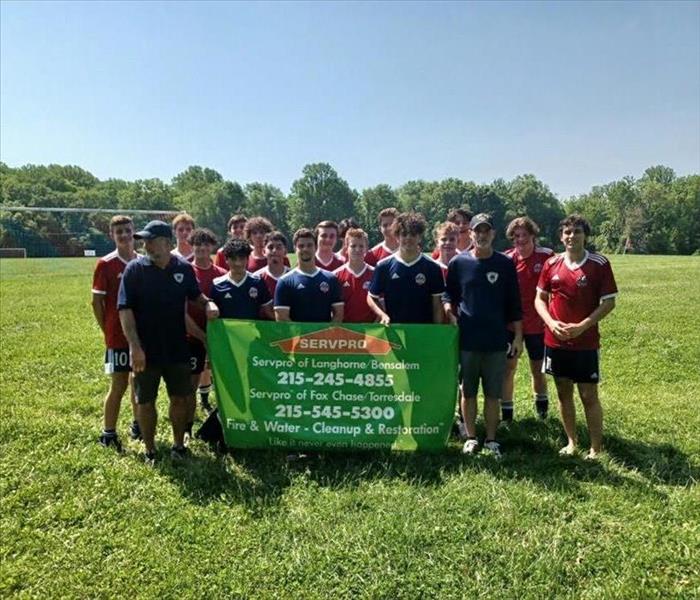 The Wolverines team of the Langhorne Neshaminy United Soccer Club holds a sign reading Servpro of Langhonre/Bensalem.