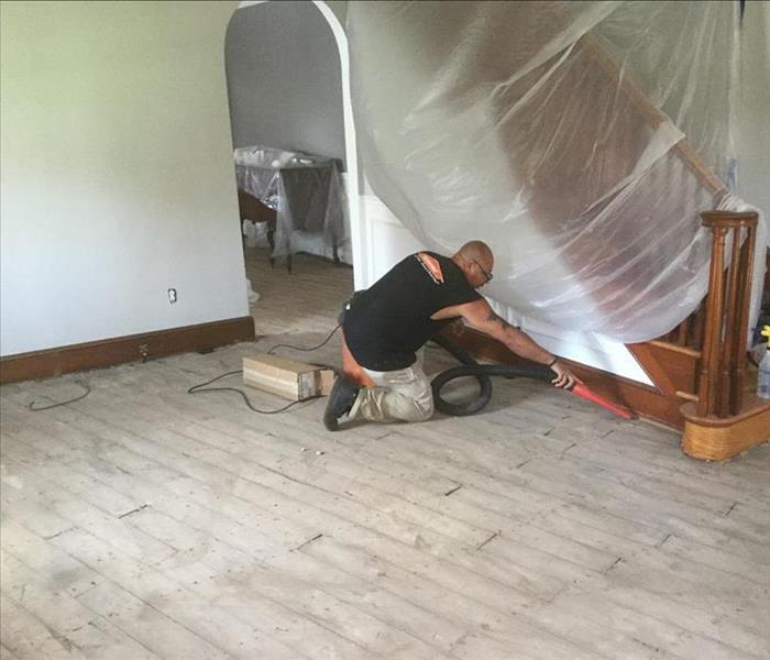 Service worker cleaning up flooring after the old floors were removed