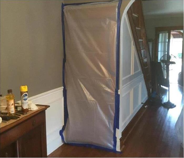 Door of a home with plastic barrier, concept of mold containment