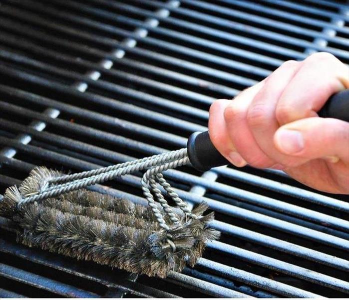 A person cleaning a grill